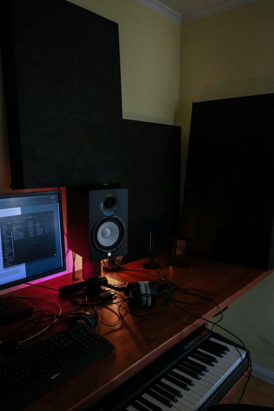 Home music studio workspace with a keyboard and monitor.