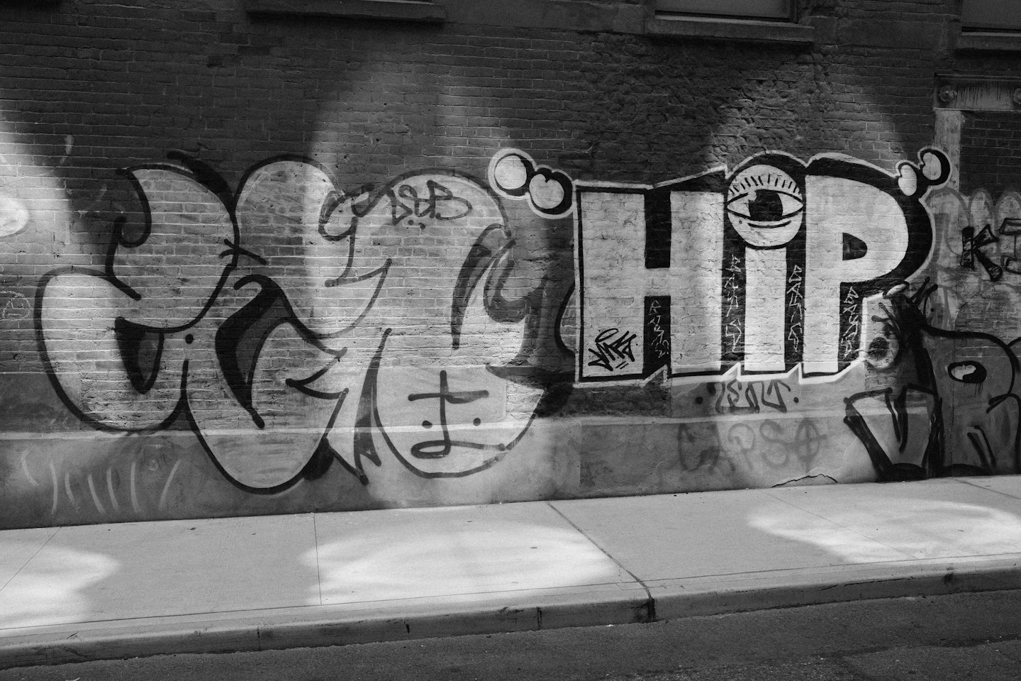 Layered urban graffiti on a textured brick wall.