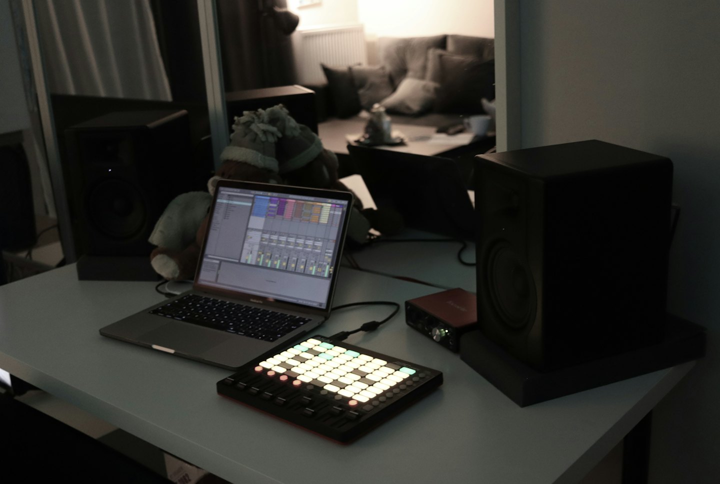 Music production equipment arranged on a desk with a laptop.